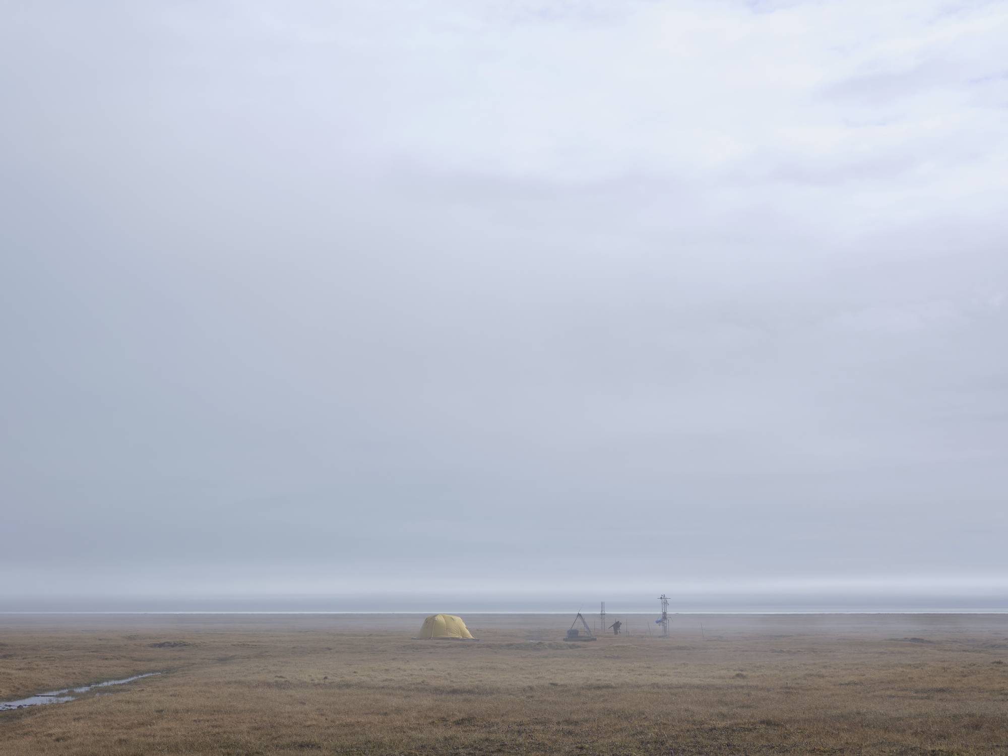 The tent. A yellow tent in a field with fog all around